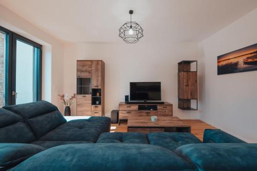 a living room with a couch and a tv at MOLO LIPNO RESIDENCE in Lipno nad Vltavou