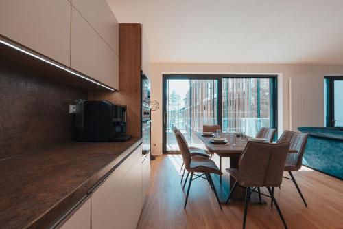 a kitchen and dining room with a table and chairs at MOLO LIPNO RESIDENCE in Lipno nad Vltavou