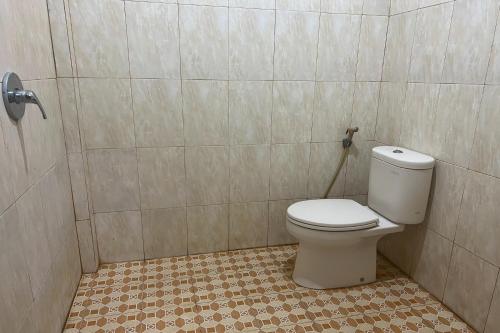 uma casa de banho com WC num quarto em azulejo em OYO 93912 Kost Takalar 