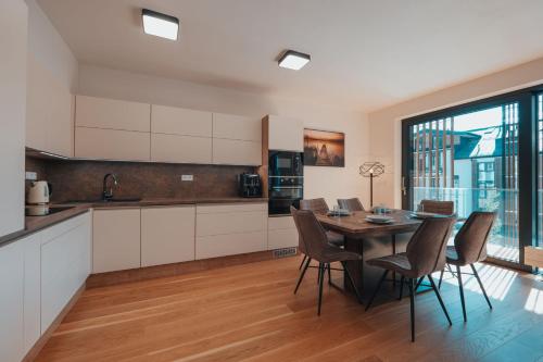 a kitchen and dining room with a table and chairs at MOLO LIPNO RESIDENCE in Lipno nad Vltavou