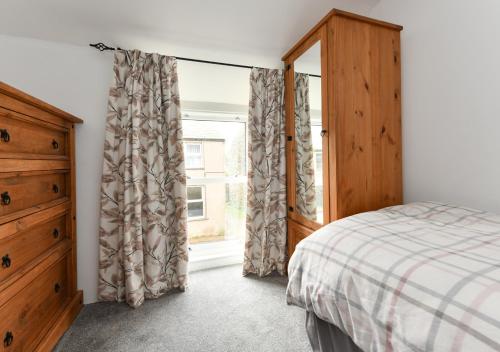 1 dormitorio con 1 cama, vestidor y ventana en Bryn Tirion, en Llanbedrog