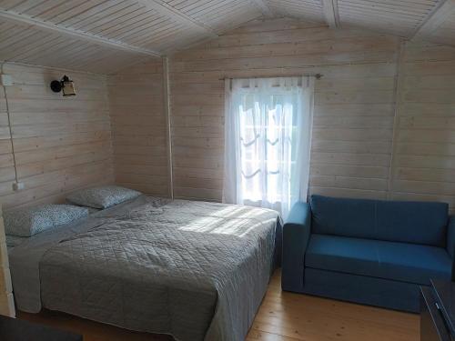 a bedroom with a bed and a blue chair at Salu summer cottage in Vadi