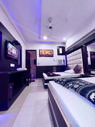 Cette chambre comprend deux lits et une télévision. dans l'établissement PEACE POINT FAMILY HOTEL By AKJ, à New Delhi
