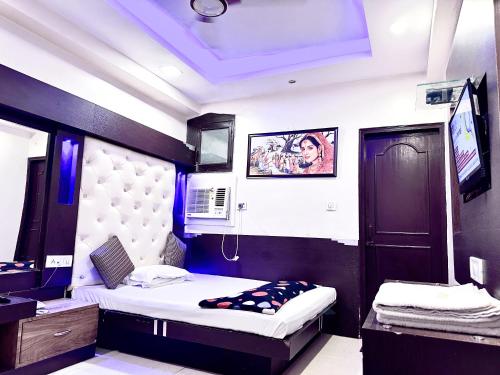 sypialnia z dwoma łóżkami i telewizorem w obiekcie PEACE POINT FAMILY HOTEL By AKJ w Nowym Delhi