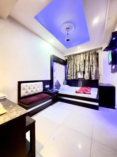 Habitación con 2 camas, mesa y TV. en PEACE POINT FAMILY HOTEL By AKJ, en Nueva Delhi