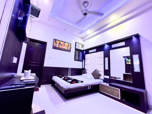 PEACE POINT FAMILY HOTEL By AKJ في نيودلهي: غرفة نوم فيها سرير ومكتب