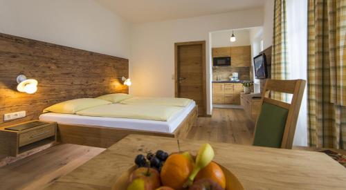 a bedroom with a bed and a table with a bowl of fruit at mühlbacher - inklusive kostenfreiem Eintritt in die Alpentherme in Bad Hofgastein