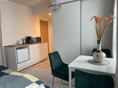 een woonkamer met een tafel en stoelen en een keuken bij A studio near to Airport in Vantaa