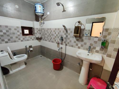 a bathroom with a toilet and a sink and a shower at Raadballi Retreat in Kangra