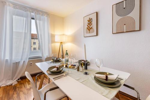 a white dining room with a white table and chairs at Spa Apartment am Bauhausmuseum in Dessau