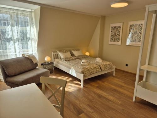 a bedroom with a bed and a couch and a chair at Pärnu Old Town apartment in Pärnu