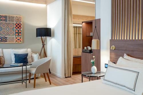 una camera da letto con un letto, una scrivania e una sedia di Meliá Granada a Granada