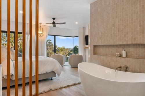 Dormitorio principal con bañera, cama y ventana en Ridge Retreat, en Toowoomba