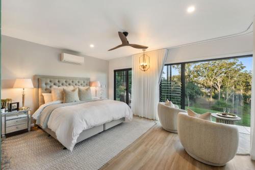 1 dormitorio con 1 cama, 2 sillas y ventana en Ridge Retreat en Toowoomba