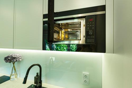 eine Küche mit einer Mikrowelle über einer Küchentheke in der Unterkunft Batorego Grey 150m do metra in Warschau