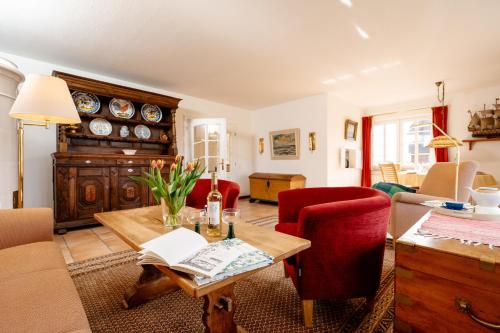 sala de estar con mesa y sillas rojas en Haus Jölhuk, en Morsum
