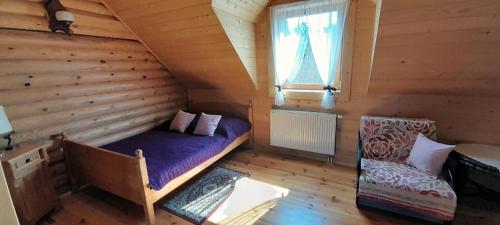 Cette chambre comprend un lit, une fenêtre et une chaise. dans l'établissement Sowi Dwór, à Nałęczów