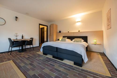 een slaapkamer met een bed, een bureau en een tafel bij B&B aan het Dijksteegje in Sint-Oedenrode