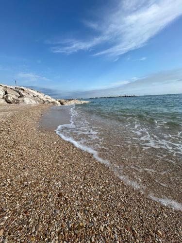a rocky beach with the ocean in the background at Endless Summer in Marina di Montemarciano