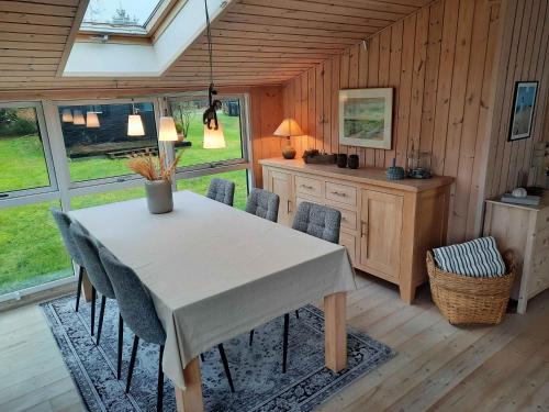 a dining room with a white table and chairs at Cozy Summer House In Lnstrup For 5 People, in Lønstrup