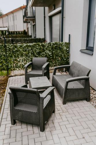 a group of chairs and tables on a patio at Apartmán v centru Železné Rudy se zahrádkou in Železná Ruda