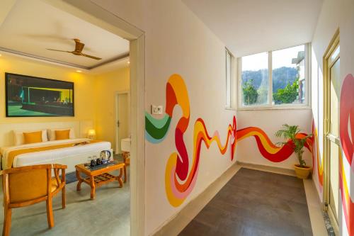 a bedroom with a mural on the wall at ArtBuzz Rishikesh in Rishīkesh