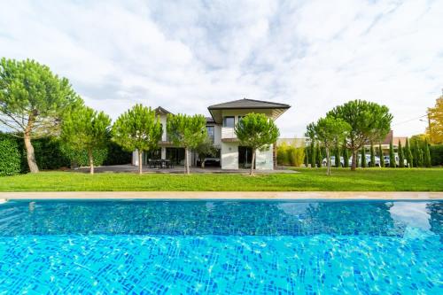 une maison avec une piscine devant une maison dans l'établissement Dream 5BD Villa for Families - Geneva Centre 14KM by GuestLee, à Veigy-Foncenex