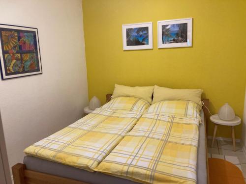 1 cama en un dormitorio con 2 cuadros en la pared en Ferienwohnungen Christoph in der Edelweißstraße en Pfaffing