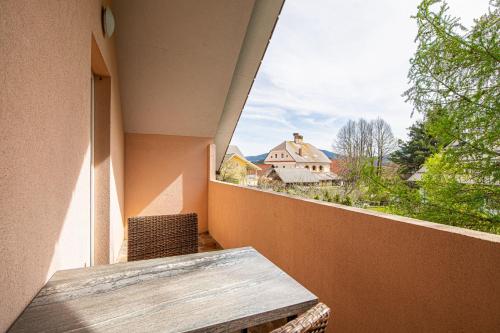 einen Balkon mit einem Tisch und Blick auf ein Haus in der Unterkunft Apartments Lavrič - Happy Rentals in Velike Bloke