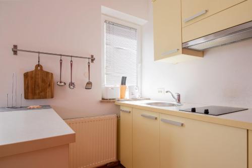 a kitchen with white cabinets and a sink and a window at Apartments Lavrič in Velike Bloke