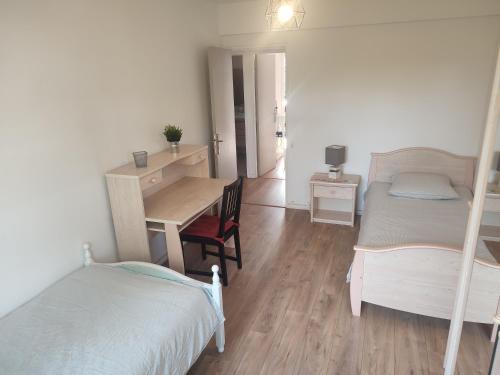 - une chambre avec 2 lits superposés, un bureau et une table dans l'établissement Grand appartement entouré de verdure, à Villejuif