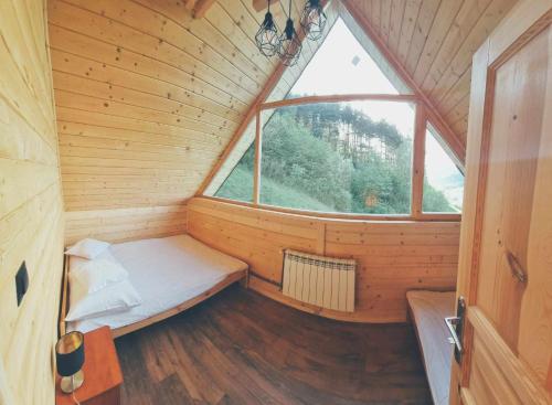 a small room with a bed and a window at Domek na zboczu in Ochotnica Górna