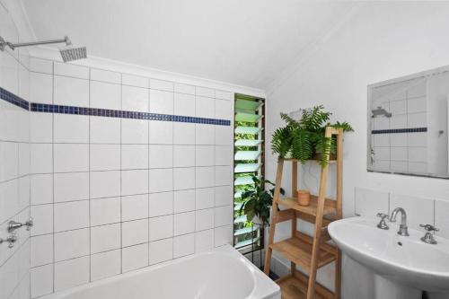 ein Badezimmer mit einem Waschbecken, einer Badewanne und einem WC in der Unterkunft Beachside Traditional Queenslander - Close to City in Machans Beach
