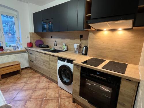 a kitchen with a stove and a washer and dryer at Stay Adventure Mrzeżyno in Mrzeżyno