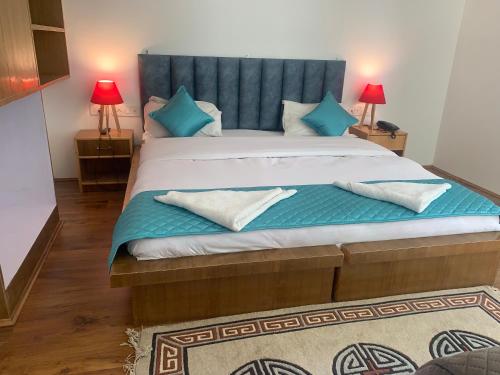 a bedroom with a large bed with a blue headboard at Adu's Eternal Comfort in Leh