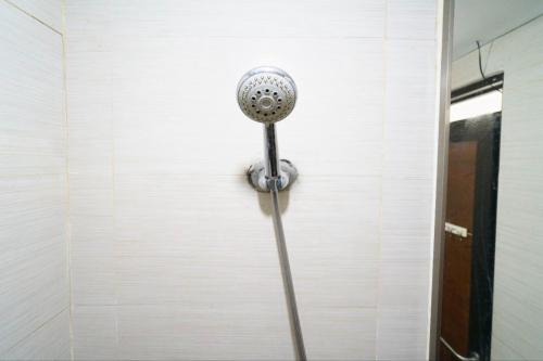 cabezal de ducha en la pared de una habitación en OYO 93940 Apartemen Mekarwangi Square By Lina, en Bandung