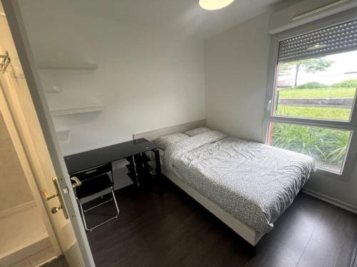 une petite chambre avec un lit et une fenêtre dans l'établissement Ds appartement élégant au pieds du tramway, à Vitry-sur-Seine