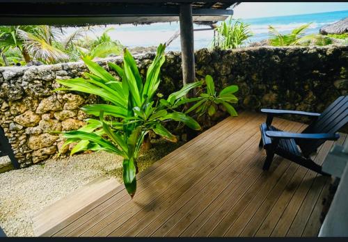 a wooden deck with a chair and a plant at Banana Bay Beach Club in Port Vila
