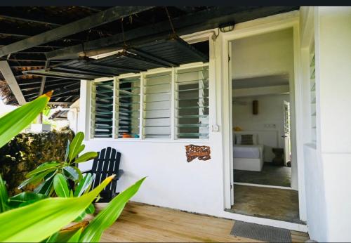 an open door of a white house with a bench at Banana Bay Beach Club in Port Vila