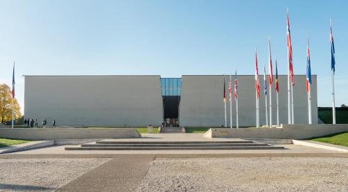 um grande edifício com bandeiras à sua frente em La colline aux oiseaux em Caen