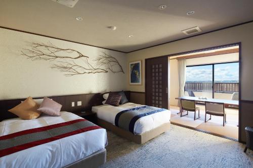 Cette chambre dispose de deux lits et d'un balcon. dans l'établissement Villa Ryusei, à Ugata
