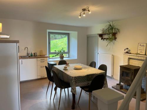 a kitchen and dining room with a table and chairs at Eole - Fermette typique Ardennaise in Sainte-Ode