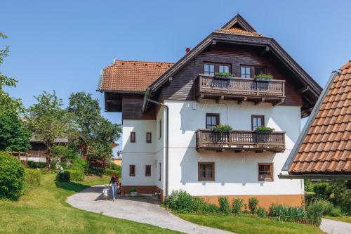 a white house with a wooden roof and balcony at Bauerborchardt - Urlaub am Bauernhof bei Familie Borchardt in Wernberg