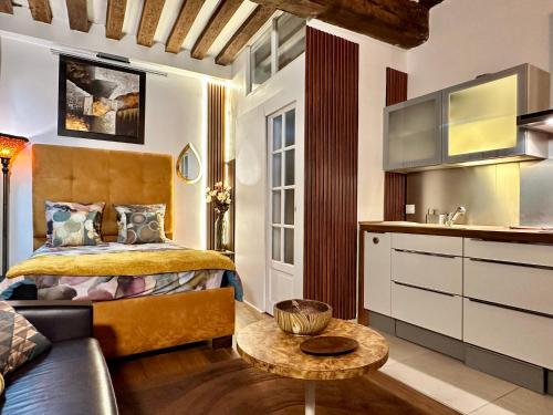 une chambre avec un lit, un canapé et une table dans l'établissement Studio design by Kenzo near Notre Dame, à Paris