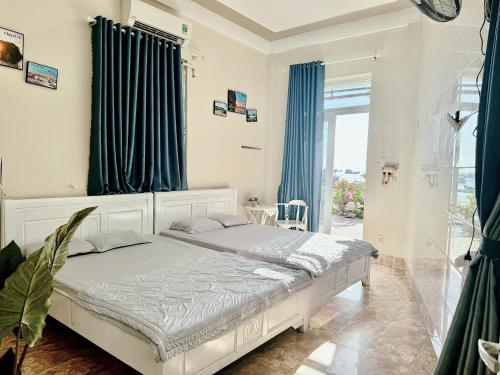 sypialnia z białym łóżkiem z niebieskimi zasłonami w obiekcie Homestay tiên tri 01 w mieście Ly Son