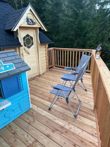 a wooden deck with a chair and a dog house at Almhaus Zirbenheim Nicolina in Flattnitz