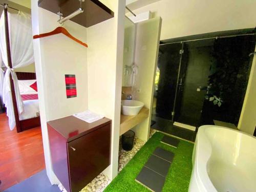 a bathroom with a bath tub and a sink at Venus- 1br pvt pool villa in kuta By iLys Collection in Kuta