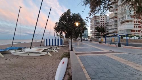 a beach with a row of boats on the sand at Incredible seafront with sunrise and sunset views in Benicàssim
