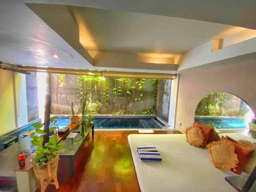 a living room with a large window and an aquarium at Venus- 1br pvt pool villa in kuta By iLys Collection in Kuta