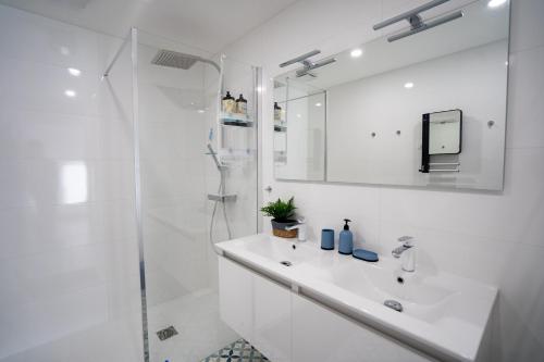 a white bathroom with a sink and a shower at Escapade Ocean in Labenne